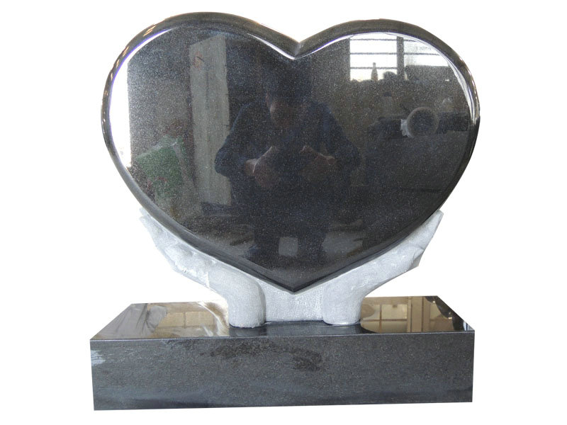 Hands Holding Heart Shaped Grave Monuments With Black Granite